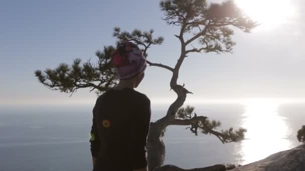 Close-up van een jonge vrouw lopen hoog in de bergen boven een zee. Dame op de top in prachtige omgeving met uitzicht op zee. — Stockvideo