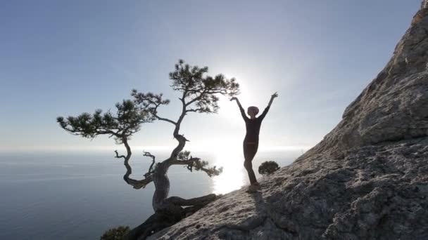 Молода жінка танцює і біжить на горі. Дама на вершині в красивих краєвидах над морем . — стокове відео