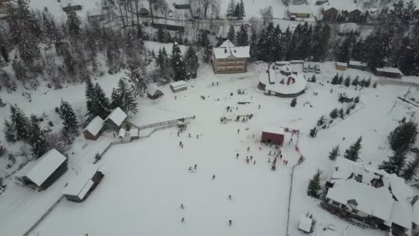 Het skigebied van de Karpaten vanaf een hoogte. Vlucht over skiliften. Vogels eye view van personen aflopend op ski's en snowboards. — Stockvideo
