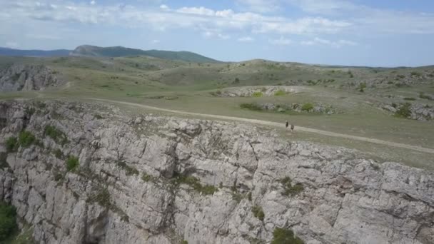 Dvě dívky chůze v horách na okraji působivou útesu na Krymu — Stock video