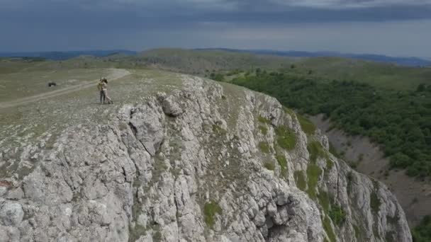 Pareja en las montañas al borde de un impresionante acantilado en Crimea — Vídeos de Stock