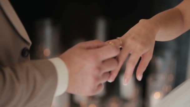Legt der Bräutigam den Ehering an den Finger der Braut. eheliche Hände mit Ringen. das Brautpaar tauscht Eheringe. — Stockvideo