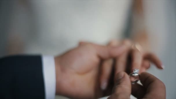 新郎把结婚戒指放在新娘的手指上。婚姻与戒指的手。新娘和新郎交换结婚戒指. — 图库视频影像