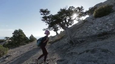 Tırmanma ve bir dağın tepesine ulaşan küçük sırt çantası olan kadın. Bayan güzel sahne zirvesinde.