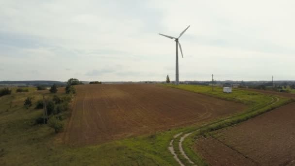 Вид з повітря на невелику окрему вітрову турбіну, що обертається швидко. Літня сільська місцевість з сільськогосподарськими полями . — стокове відео