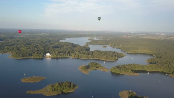 Globos de aire caliente volando sobre hermosos lagos e islas en Lituania cerca del castillo de Trakai en verano. Vista aérea . — Vídeos de Stock