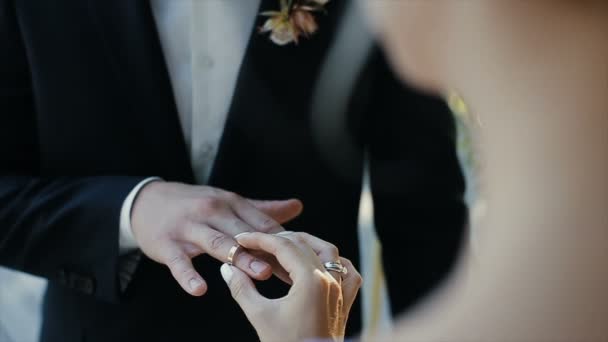 La novia pone el anillo de boda en el dedo del novio. manos de matrimonio con anillos. La novia y el novio intercambian anillos de boda . — Vídeos de Stock