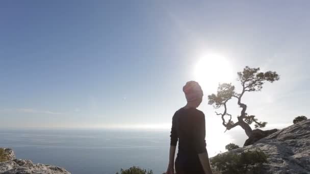 Jonge vrouw wandelen en lopen op een berg. Dame op de top in prachtige omgeving geconfronteerd met de kust. — Stockvideo