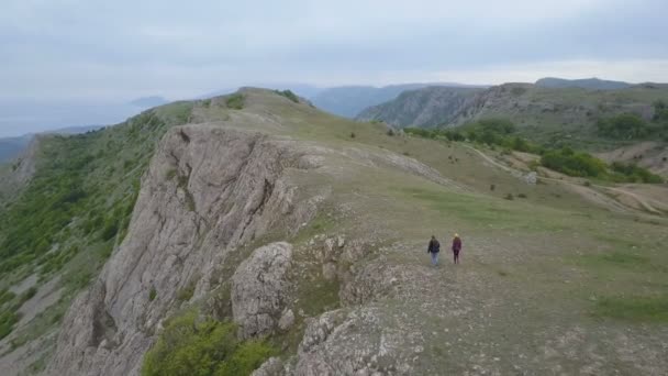 Überfliegerpaar genießt schöne Aussicht in die Berge. Zwei händchenhaltende Personen wandern im Freien — Stockvideo