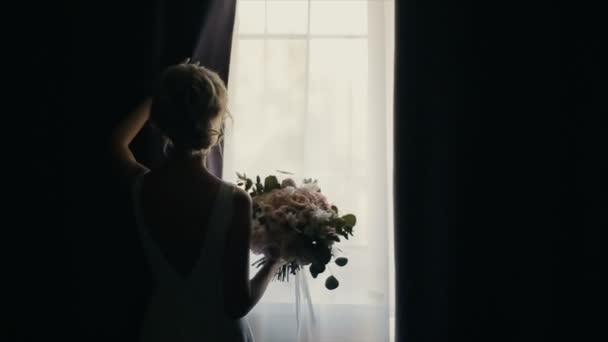 Belle mariée avec bouquet ouvre un rideau. Silhouette — Video