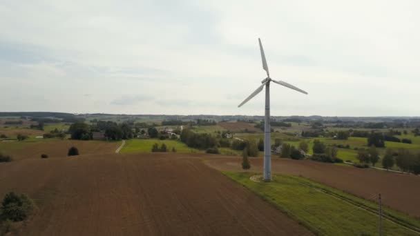 Вид з повітря на одну вітрову турбіну, що обертається швидко. Літня сільська місцевість з сільськогосподарськими полями . — стокове відео