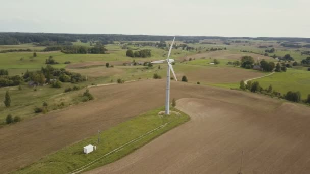 Flygfoto över enstaka vindkraftverk roterande snabbt. Sommaren landskapet med åkrar. — Stockvideo