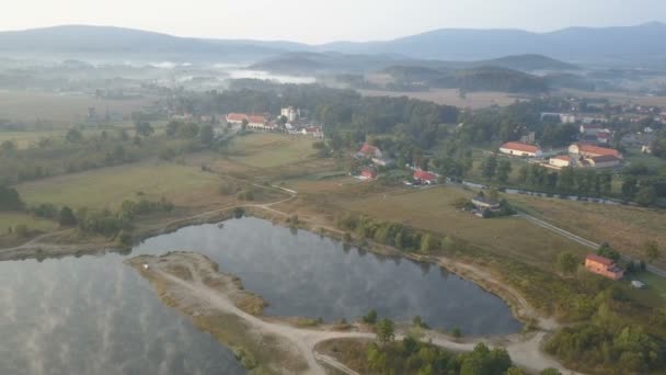 Αεροφωτογραφία του μεσαιωνικού παλατιού στα βουνά. Ομίχλη το πρωί πάνω από μια λίμνη. Wojanow, Πολωνία — Αρχείο Βίντεο