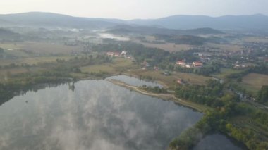 Havadan görünümü Dağları Ortaçağ Sarayı. Sabah sis bir göl üzerinde. Wojanow, Polonya