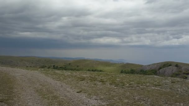 崖の端に向かって農村部の山の未舗装の道路上の飛行。岩、森、クリミア半島の海の素晴らしい空撮 — ストック動画