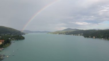 Bir göl üzerinde bir gökkuşağı hava görünümünü. Tekne gölün üzerinde taşır. Klagenfurt Carinthia Avusturya.