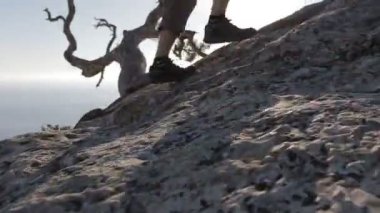 Bir dağa tırmanan bir adamın yakın çekim takip dinamik. Dağcılık botlar ve maceracı adam dağ zirvesine tırmanma detay