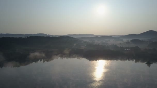 电影空中在山湖上空的晨雾中飞行。雾蒙蒙的日出在山里. — 图库视频影像