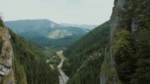 Vista aérea de un camino de montaña en una hermosa garganta profunda. Los coches se mueven en un camino de montaña . — Vídeo de stock
