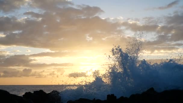 Golven stijgen in de lucht bij mooie zonsondergang licht. Big Wave is crashen op rotsen en spuiten. Close-up weergave van een spray in de voorkant van de camera. Stralen van de vaststelling of de stijgende zon zee golven op de wal close-up. — Stockvideo