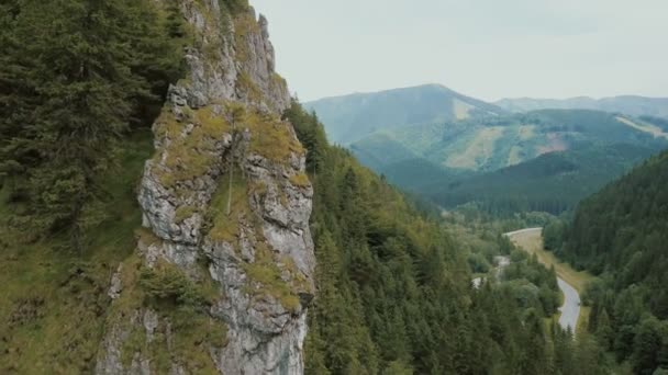 Вид з повітря на гірську дорогу в красивій глибокій ущелині. Автомобілі рухаються по гірській дорозі . — стокове відео