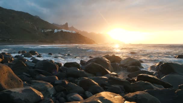 Les vagues de l'océan s'écrasent sur les rochers et pulvérisent dans la belle lumière du coucher du soleil au ralenti sur la plage de Benijo à Tenerife, îles Canaries . — Video