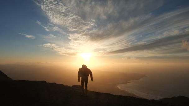Silueta de un hombre optimista saltando contra una hermosa puesta de sol en cámara lenta . — Vídeo de stock