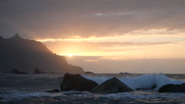 Les vagues se lèvent dans l'air à la belle lumière du coucher du soleil à la plage de Benijo à Tenerife, îles Canaries. Grosse vague s'écrase sur les rochers et la pulvérisation . — Video