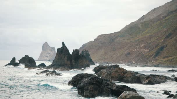 De grosses vagues s'écrasent sur les rochers et pulvérisent. Mouvement lent — Video