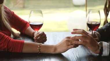 Elele ve romantik akşam yemeği sırasında kırmızı şarap bardakları tokuşturup sevgi dolu çiftin yakın çekim