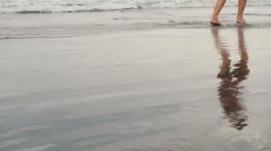 Tenerife, Kanarya Adaları siyah kum plajda koşu çekici genç kadın izleme çekim. Bulutlu sahil arka plan kadın