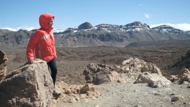 Mujer joven caminando en las montañas y observando un enorme cráter del volcán Teide en Tenerife, Islas Canarias, España . — Vídeo de stock