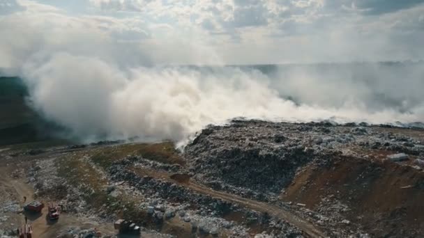 Vista aérea del vertedero de basura en llamas que contamina el medio ambiente. El fuerte viento eleva el humo tóxico de la quema de basura en el aire y lo extiende a larga distancia . — Vídeo de stock