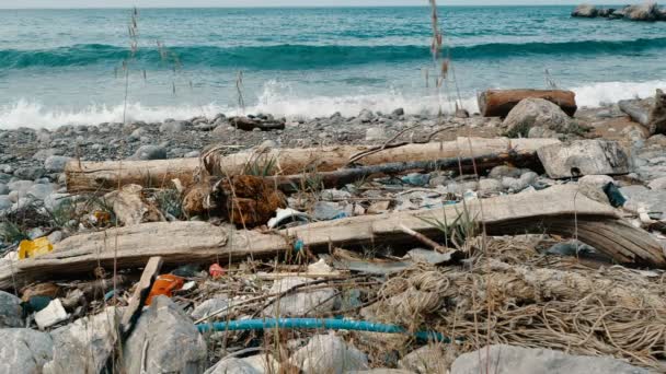 Мусор, пластик, мусор, загрязнение окружающей среды на пляже. Волны в замедленной съемке на заднем плане. Мусор, пластиковая бутылка на пляже. Отходы, загрязняющие окружающую среду океана — стоковое видео