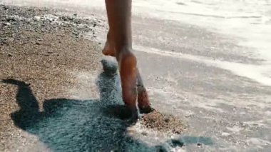Aktif sportif yalınayak kadın sahil boyunca yavaş hareket çalışır. Kadın fitness, koşu eğitimi ve spor aktivitesi