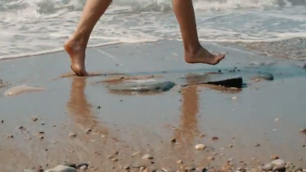 Movimiento lento: pies de las mujeres corriendo en la playa de arena caliente y soleada . — Vídeos de Stock