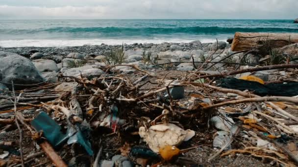 Odpad, plasty, odpadky, znečištění životního prostředí na pláži. Vlny v pomalém pohybu na pozadí. Popelnice, plastová láhev na pláži. Odpady, které znečišťuje mořské prostředí — Stock video