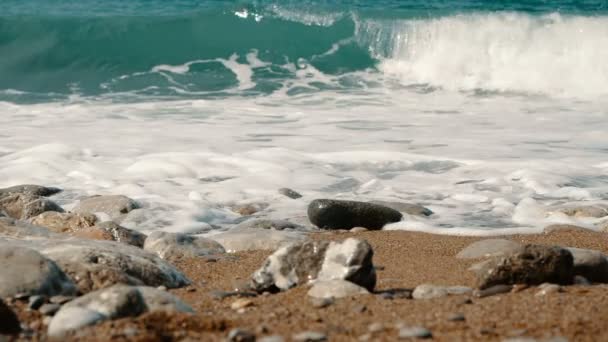 Fale morskie są upaść na kamienie i oprysków w zwolnionym tempie. Piękna plaża na Krymie z kamieniami i piaskiem, — Wideo stockowe