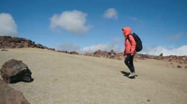Tenerife, Kanarya adaları, İspanya Teide yanardağ büyük bir krater lav kayalar arasında volkanik kum boyunca yürüyen sırt çantası ile genç bir kadının izleme çekim.
