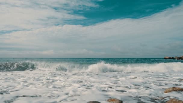 海の波は石に衝突し、スローモーションで噴霧しています。石と砂とクリミアの美しいビーチ, — ストック動画