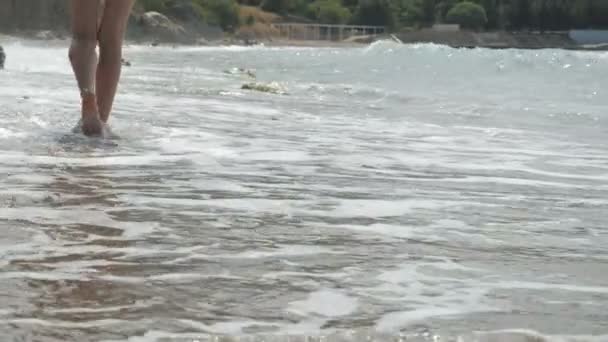 Activa mujer descalza deportiva camina a lo largo de la orilla del mar en movimiento lento. Mujer fitness, entrenamiento de jogging y actividad deportiva — Vídeos de Stock