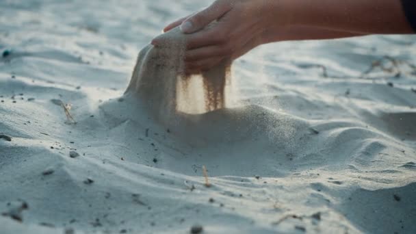 SLOW MOTION, FLOSE UP: A areia passa pelos dedos de uma jovem mulher. A areia está correndo através dos dedos de uma senhora e é espalhada por um vento forte . — Vídeo de Stock