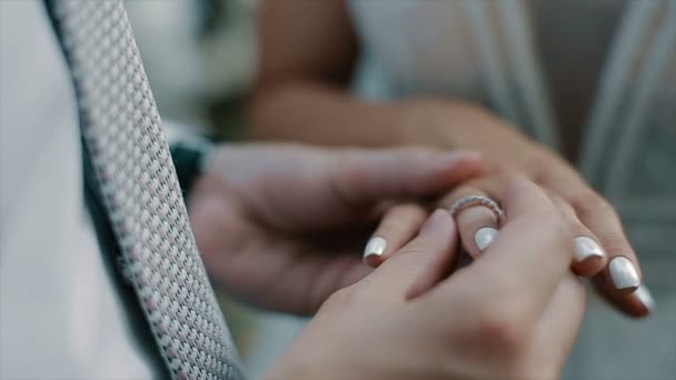 Brudgummen sätter vigselringen på brudar finger. Äktenskap, händer med ringar. Bruden och brudgummen utbyter vigselringar. — Stockvideo