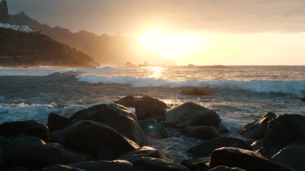 Le onde dell'oceano si infrangono sulle rocce e spruzzano in bella luce del tramonto sulla spiaggia di Benijo a Tenerife, Isole Canarie. Rallentatore . — Video Stock