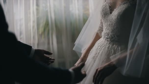 Wedding couple holding hands in front of a window — Stock Video
