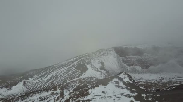 Luftaufnahme des Kraters eines Vulkans pico viejo auf Teneriffa, bedeckt mit Schnee und Wolken. — Stockvideo