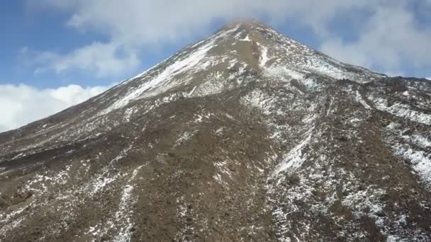 Letecký pohled na vrchol sopky Teide na Tenerife, pokrytý sněhem a mraky. — Stock video