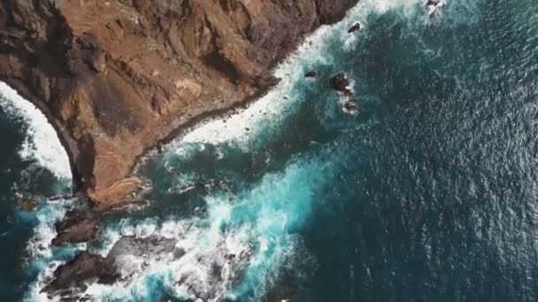 Antenn topputsikt över havsvågor bryta på stenar. Blått vatten och vitt skum på Teneriffa, Kanarieöarna, Spanien — Stockvideo