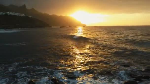 Havadan görünüm. Okyanus dalgaları, Tenerife 'deki Benijo plajına yakın güzel gün batımı ışığında kayalar ve sprey üzerinde çökmesine neden olur. — Stok video