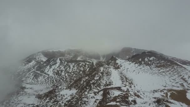 Vista aérea del cráter de un volcán pico Viejo en Tenerife, cubierto de nieve y nubes. Vuelo sobre volcán bajo tormenta de nieve acercándose — Vídeos de Stock